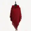 Poncho en maille rouge bordeaux avec capuche fourrée et franges.