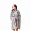 Poncho couverture plaid gris avec capuche et boutons.