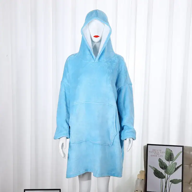 Poncho plaid bleu ciel avec capuche et poches, présenté sur mannequin.