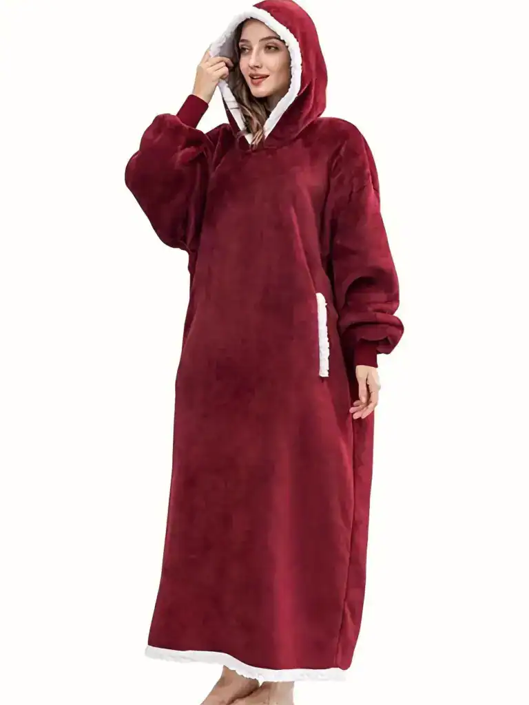 Poncho plaid rouge avec capuche doublée de blanc et poches.