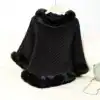 Poncho plaid noir à capuche avec bordure en fourrure synthétique, style intérieur élégant.