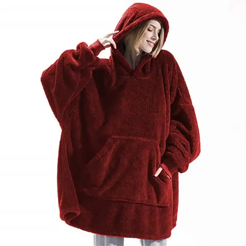 Poncho plaid polaire rouge, capuche, poches avant, look confortable.