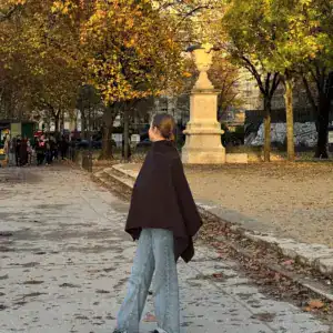 Poncho cape marron porté lors d'une promenade dans un parc en automne