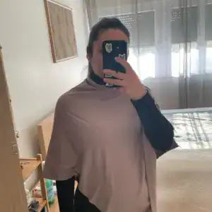 Poncho taupe porté sur un haut noir