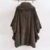 Poncho plaid sans capuche en tissu doux marron, suspendu à un cintre.