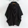 Poncho plaid noir sans capuche, texture douce et poches avant.