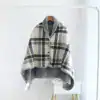 Poncho polaire à carreaux gris et blanc avec capuche doublée et boutons.