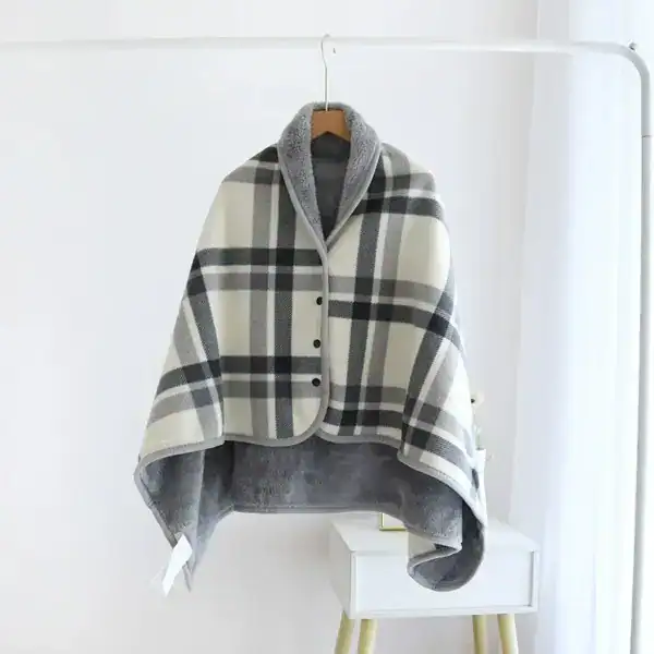 Poncho polaire à carreaux gris et blanc avec capuche doublée et boutons.