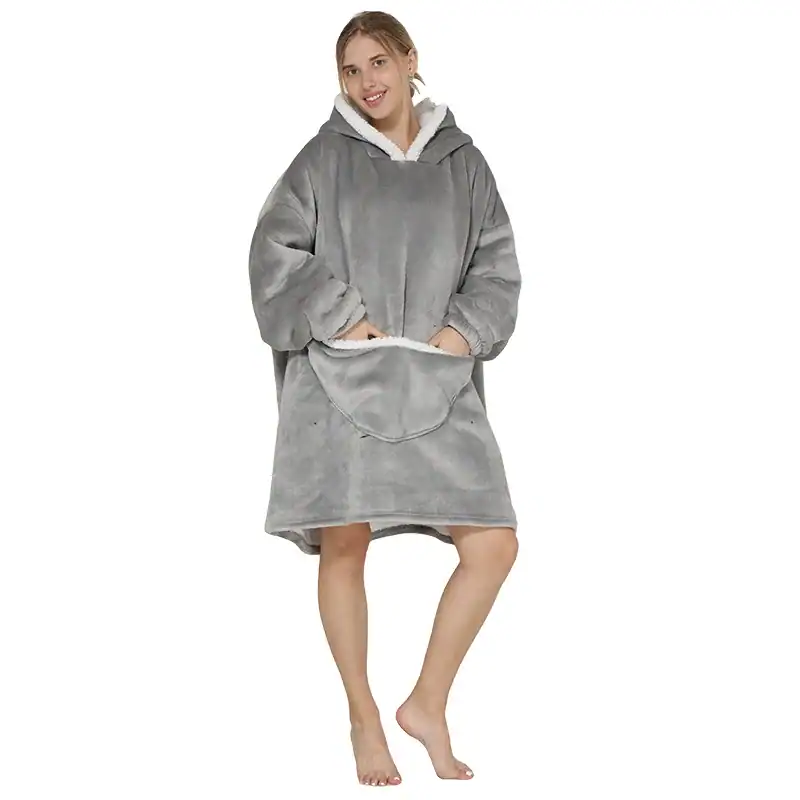 Poncho polaire femme gris avec capuche doublée et poches avant.